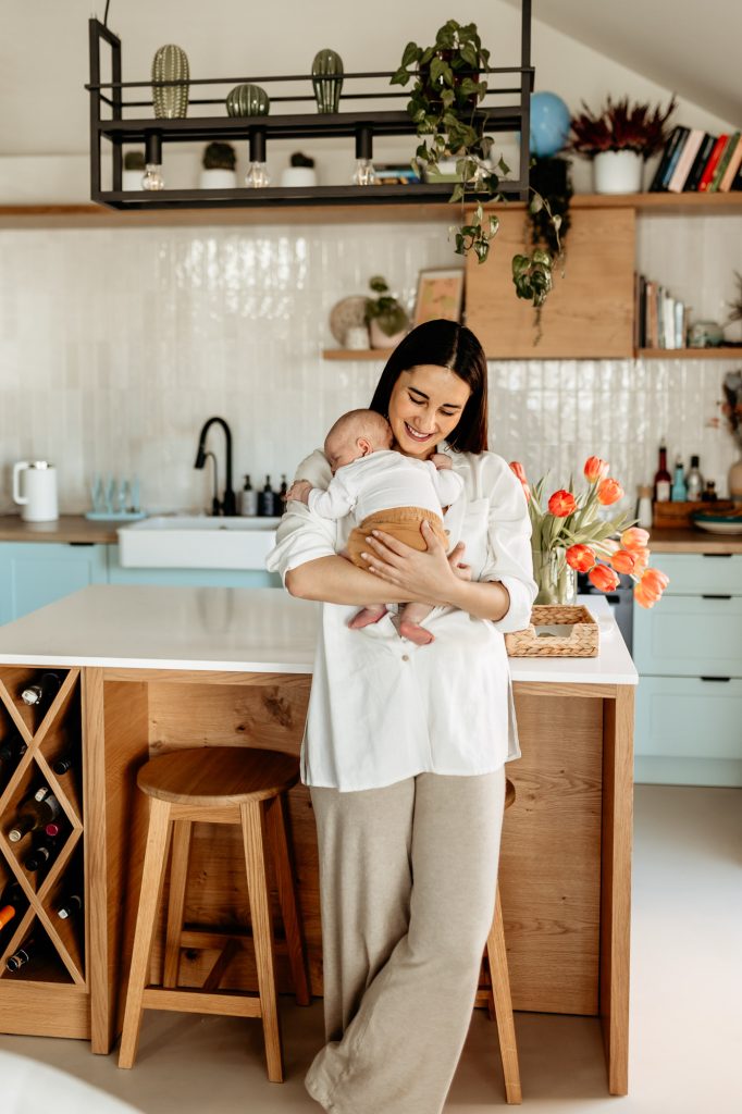 jaki termin najlepszy na sesje noworodkową. Sesja Kraków z noworodkiem - mama tuli maleństwo przy oknie